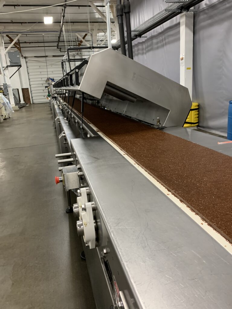 Product slab moving through a cooling tunnel on a Snackteva client production line