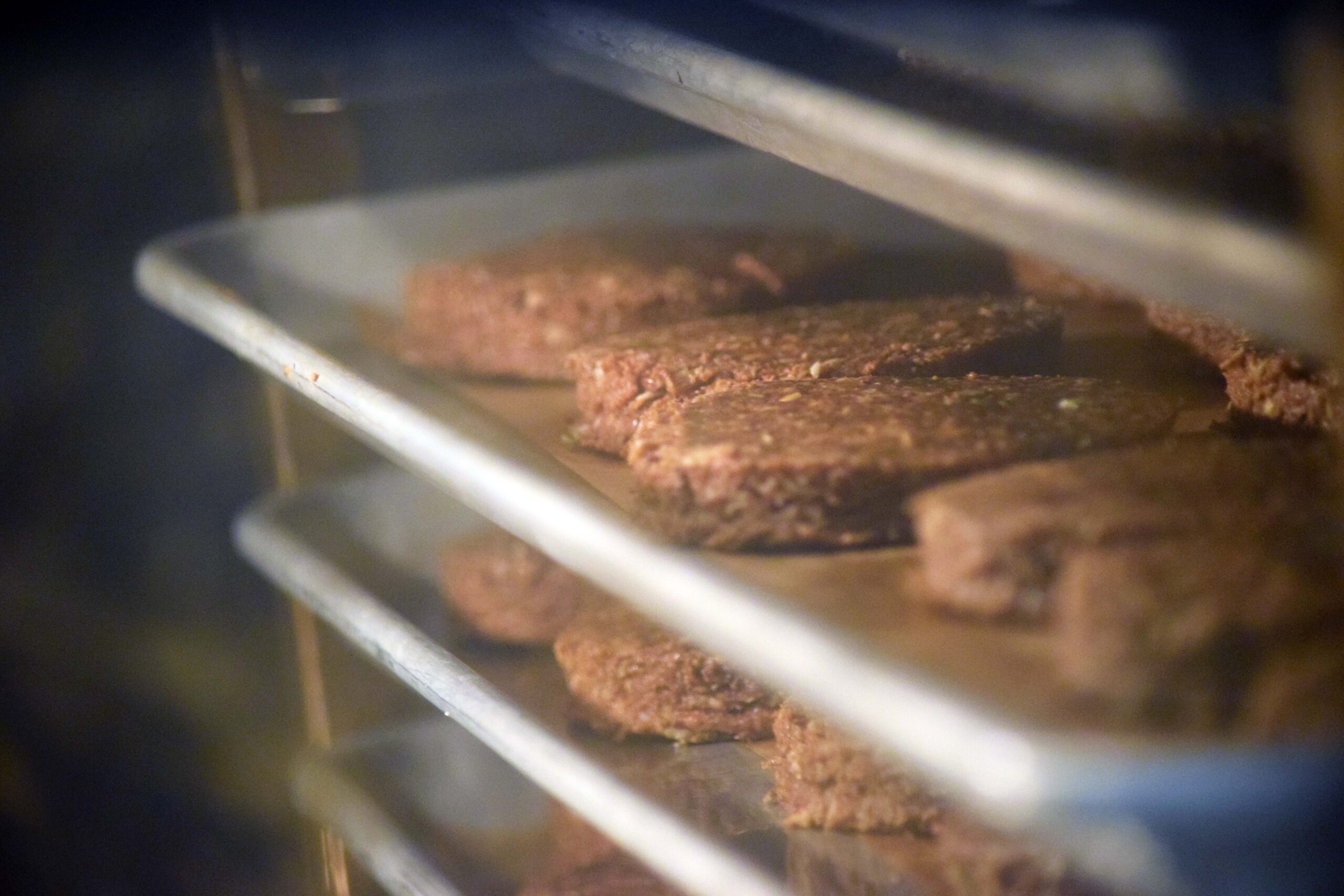 Round protein bars baking on sheet trays inside a commercial rack oven