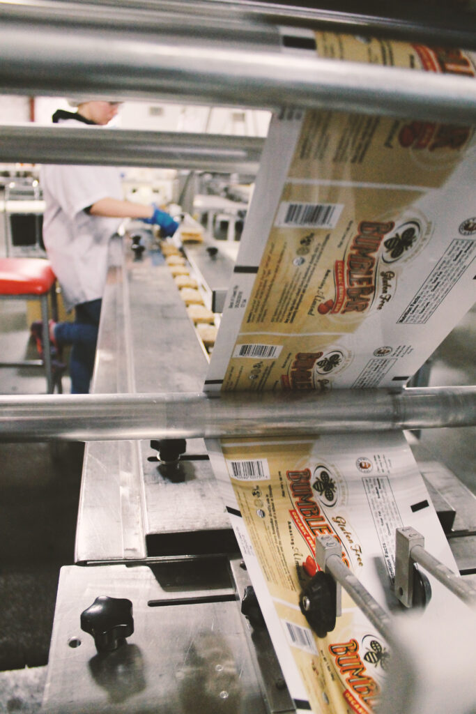BumbleBar branded film feeding through a flow wrapping machine with bars on the production line