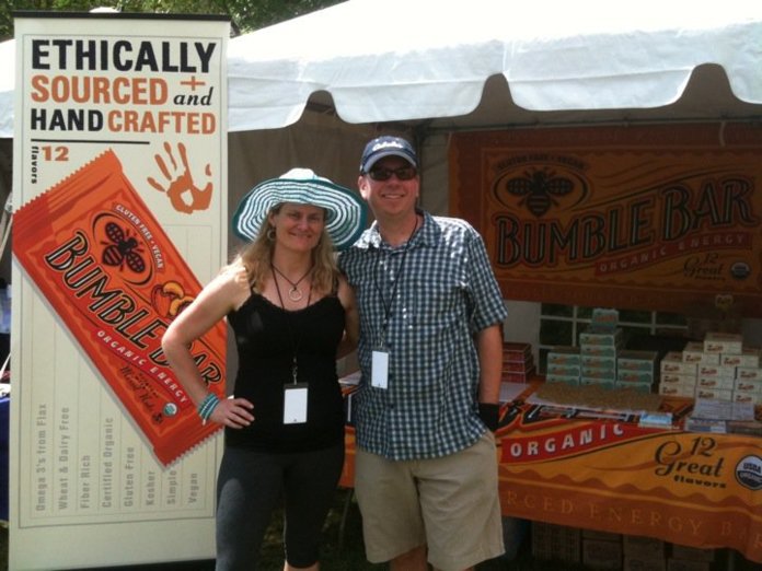 Glenn and Liz Ward at a BumbleBar festival booth in Boulder, Colorado, beside an Ethically Sourced and Hand Crafted banner