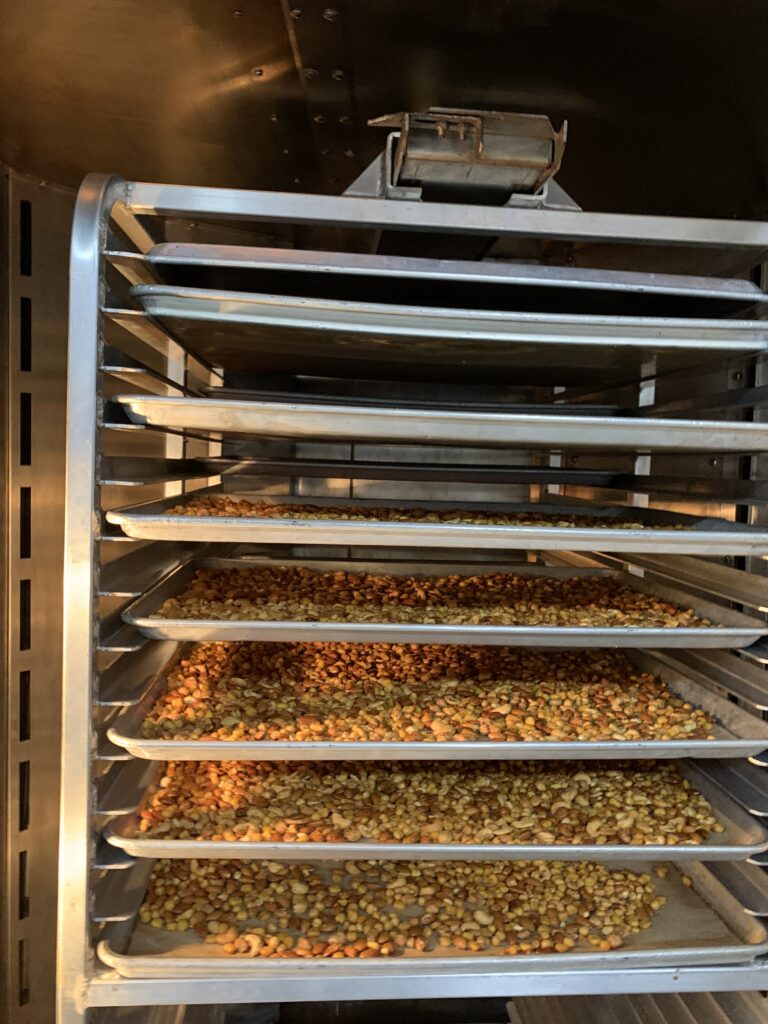 Nuts roasting on trays inside a double rotating rack oven