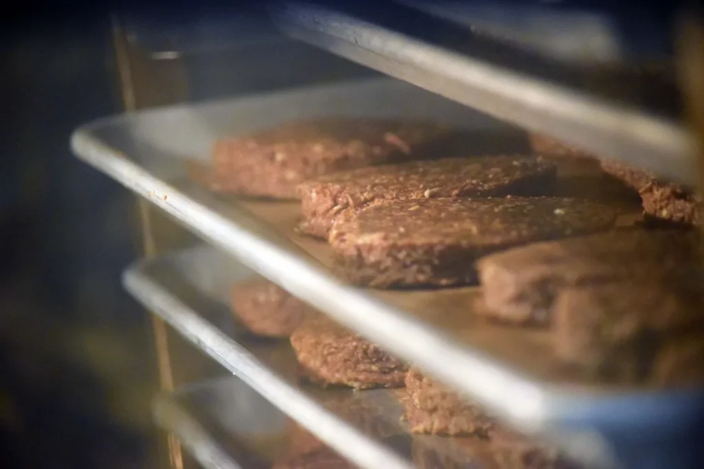 Round protein bars baking on sheet trays inside a commercial rack oven
